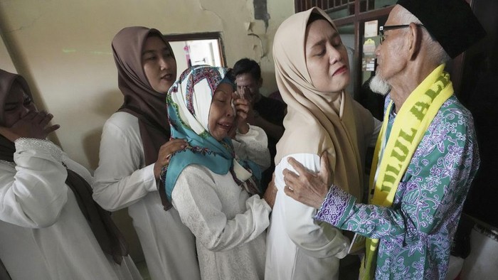 Husin bin Nisan, center, bids farewell to relatives prior to his departure for the hajj pilgrimage at his house in Tangerang, Indonesia, Tuesday, June 6, 2023. (AP Photo/Achmad Ibrahim)