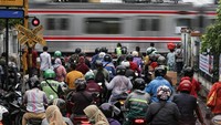 Sejumlah pengendara menunggu kereta api melintas di pintu perlintasan kereta api Pejaten Timur, Pasar Minggu, Jakarta, Senin (19/6/2023).  