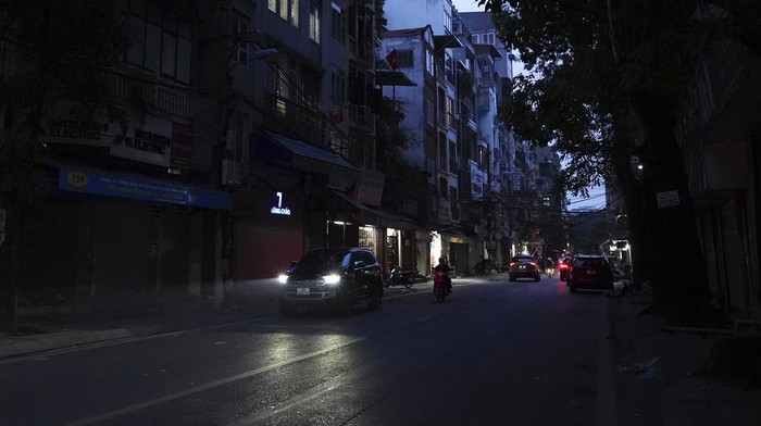 Potret Krisis Listrik di Vietnam Gegara Gelombang Panas Berkepanjangan Drivers and motorcyclists move through a street during a blackout in Hanoi, Vietnam, on June 8, 2023. Vietnam has released a long-anticipated energy plan meant to take the country through the next decade and help meet soaring demand while reducing carbon emissions. (AP Photo/Hau Dinh)