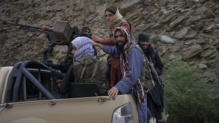 A unit of Taliban fighters ride in a pickup truck on a road in Wardak province, Afghanistan, Sunday, June 18, 2023. (AP Photo/Rodrigo Abd)