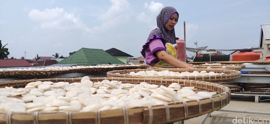 Salah satu pegawai toko kemplang dan kerupuk Rizkyanti, sedang menjemur kemplang dan kerupuk yang siap akan di produksi. (Welly Jasrial Tanjung/detikSumbagsel)