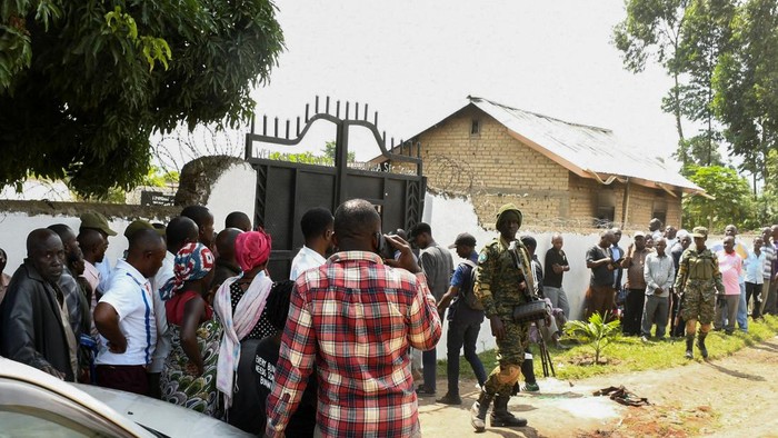 Locals gather at the cordoned scene outside the Mpondwe Lhubirira Secondary School, after militants linked to rebel group Allied Democratic Forces (ADF) killed and abducted multiple people, in Mpondwe, western Uganda, June 17, 2023. REUTERS/Stringer REFILE - QUALITY REPEAT