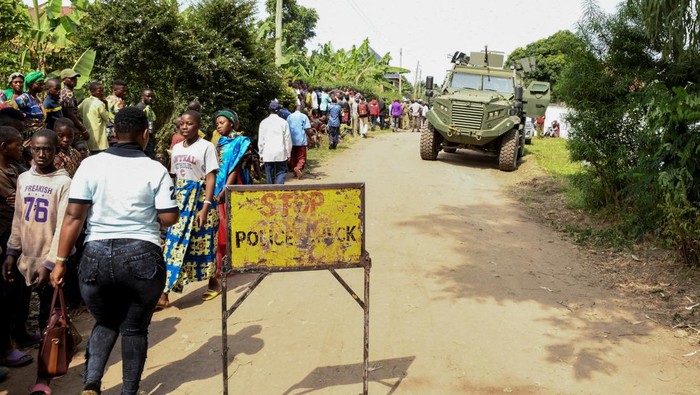 Uganda Mencekam, Puluhan Orang Tewas Akibat Serangan Pemberontak Locals gather at the cordoned scene outside the Mpondwe Lhubirira Secondary School, after militants linked to rebel group Allied Democratic Forces (ADF) killed and abducted multiple people, in Mpondwe, western Uganda, June 17, 2023. REUTERS/Stringer REFILE - QUALITY REPEAT