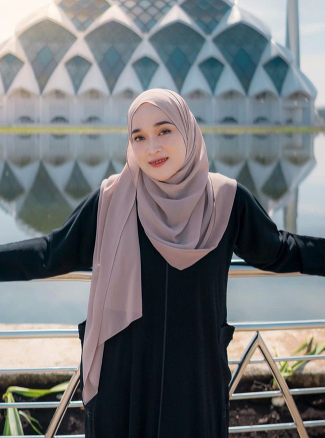 Gaya hijab simple dengan scarf segi empat dan gamis panjang menjadi andalan Ririe Fairus. Foto: Instagram @ririe_fairus