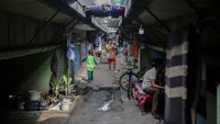 Sejumlah warga berdiri di kawasan permukiman di bawah jalan tol dalam kota Cawang-Tomang-Pluit di Jelambar Baru, Jakarta Barat, Selasa (20/6/2023).  
