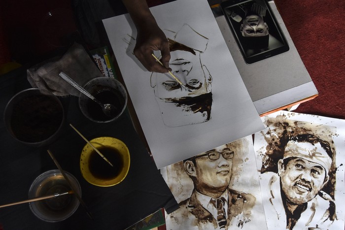 Seniman lukis Dian Gurbada melukis wajah bakal calon Presiden Ganjar Pranowo di rumahnya Perum Jati Indah, Kabupaten Ciamis, Jawa Barat, Senin (19/6/2023). Dian melukis wajah sejumlah tokoh politik nasional menggunakan bahan ampas kopi yang dikerjakan selama sehari dan lukisan tersebut beraroma wangi kopi alami yang dijual dengan harga Rp500 ribu hingga Rp2.5 juta per lukisan. ANTARA FOTO/Adeng Bustomi/tom.