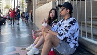 Kalau ini momen Olivia dan Denny ketika liburan di New York. Mereka beristirahat di pinggir jalan sambil menikmati es krim. Foto: Instagram @oliviasumargo