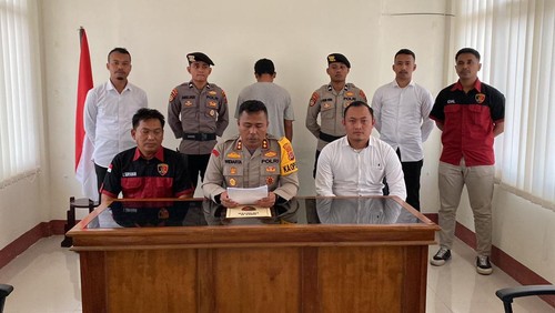 Kapolres Manggarai Timur AKBP I Ketut Widiarta memberi penjelasan tentang penetapan tersangka TPPO dengan inisial LJ yang berdiri menghadap tembok.