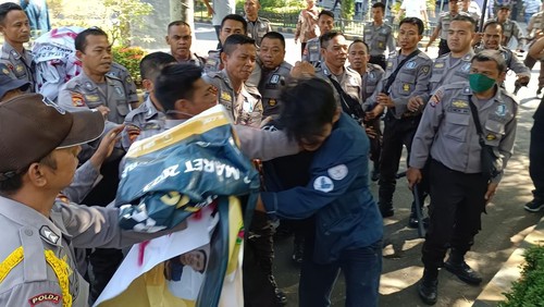 Seorang mahasiswa Unram yang diamankan satpam kampus saat aksi demonstrasi, Selasa (20/6/2023).
(Foto: BEM Unram)