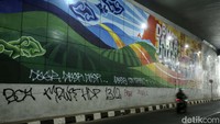Coretan yang mengotori underpass itu berwarna putih dan hitam.  