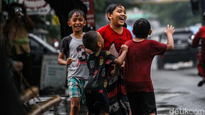 Hujan yang mengguyur kawasan Tangerang Selatan (Tangsel) membuat sejumlah jalan tergenang. Genangan air dimanfaatkan anak-anak bermain cipratan.