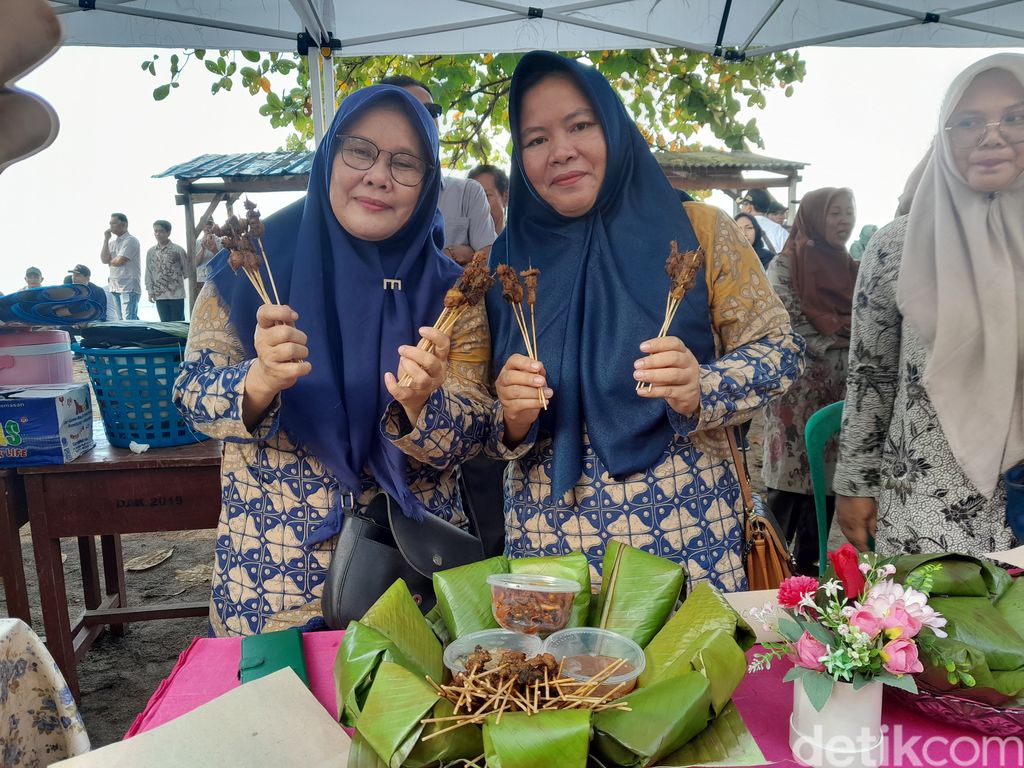 Peserta Festival Gurita 2023 menunjukkan sate gurita hasil olahan mereka.