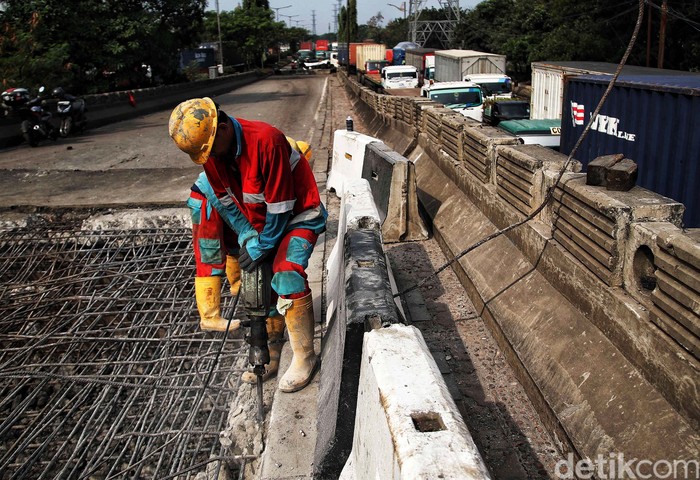 Sejumlah petugas memperbaiki jembatan yang ambles di kawasan Jalan Raya Marunda, Cilincing, Jakarta Utara, Selasa (20/6/2023). Kemacetan yang terjadi sejak Senin (19/6/2023) ini disebabkan adanya perbaikan aspal di Jembatan Marunda yang ambles pada Sabtu (17/6/2023).