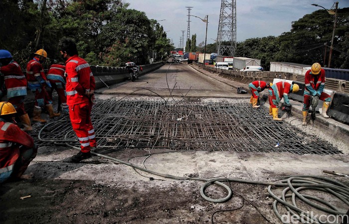 Sejumlah petugas memperbaiki jembatan yang ambles di kawasan Jalan Raya Marunda, Cilincing, Jakarta Utara, Selasa (20/6/2023). Kemacetan yang terjadi sejak Senin (19/6/2023) ini disebabkan adanya perbaikan aspal di Jembatan Marunda yang ambles pada Sabtu (17/6/2023).