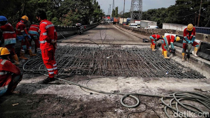 Sejumlah petugas memperbaiki jembatan yang ambles di kawasan Jalan Raya Marunda, Cilincing, Jakarta Utara, Selasa (20/6/2023). Kemacetan yang terjadi sejak Senin (19/6/2023) ini disebabkan adanya perbaikan aspal di Jembatan Marunda yang ambles pada Sabtu (17/6/2023).