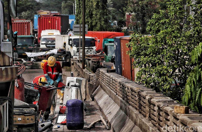 Sejumlah petugas memperbaiki jembatan yang ambles di kawasan Jalan Raya Marunda, Cilincing, Jakarta Utara, Selasa (20/6/2023). Kemacetan yang terjadi sejak Senin (19/6/2023) ini disebabkan adanya perbaikan aspal di Jembatan Marunda yang ambles pada Sabtu (17/6/2023).