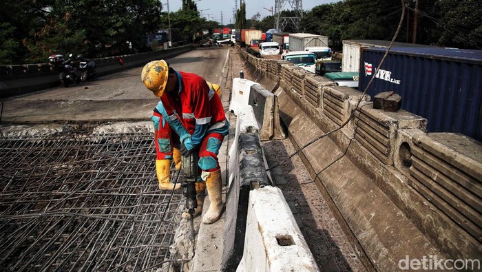 Sejumlah petugas memperbaiki jembatan yang ambles di kawasan Jalan Raya Marunda, Cilincing, Jakarta Utara, Selasa (20/6/2023). Kemacetan yang terjadi sejak Senin (19/6/2023) ini disebabkan adanya perbaikan aspal di Jembatan Marunda yang ambles pada Sabtu (17/6/2023).