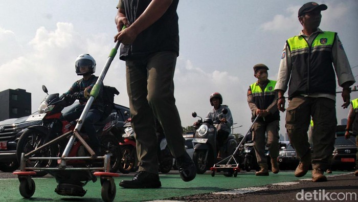 Satpol PP Modifikasi Speaker Jadi Alat Penyapu Ranjau Paku Petugas Satpol PP melakukan razia ranjau paku dengan menyisir jalan Gatot Subroto, Jakarta, Rabu (21/6/2023). Mereka memodifikasi speaker sound system, memanfaatkan magnetnya untuk mengambil paku dan benda tajam lain. Petugas menyisir dari simpang susun Semanggi hingga depan gedung Kementrian Kehutanan.
