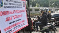 Spanduk berisi tentang dilakukannya Operasi Saber Ranjau Paku terpampang di atas mobil bak Satpol PP.