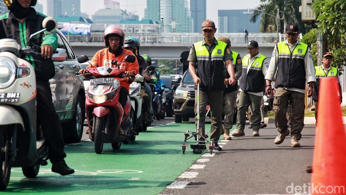 Petugas Satpol PP melakukan razia ranjau paku dengan menyisir jalan Gatot Subroto, Jakarta, Rabu (21/6/2023). Mereka memodifikasi speaker sound system, memanfaatkan magnetnya untuk mengambil paku dan benda tajam lain. Petugas menyisir dari simpang susun Semanggi hingga depan gedung Kementrian Kehutanan.