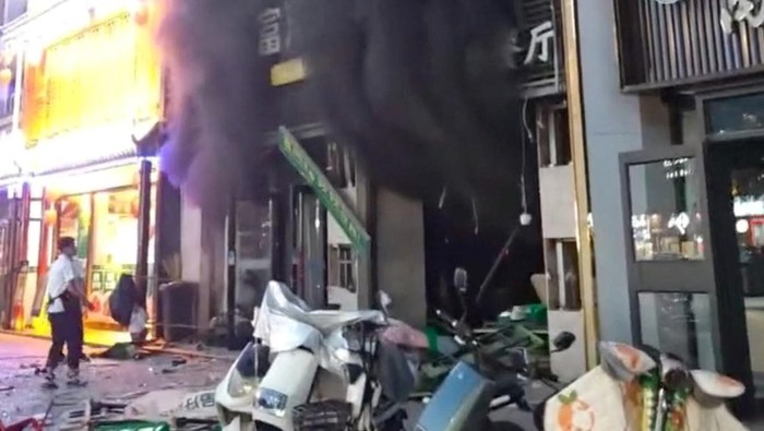 CHINA-BLAST/ A child looks at the building on fire following a gas explosion at a barbecue restaurant in Yinchuan city, Ningxia, China, on June 21, 2023 in this screengrab obtained from a handout video. Video Obtained By Reuters/Handout via REUTERS THIS IMAGE HAS BEEN SUPPLIED BY A THIRD PARTY. NO RESALES. NO ARCHIVES.