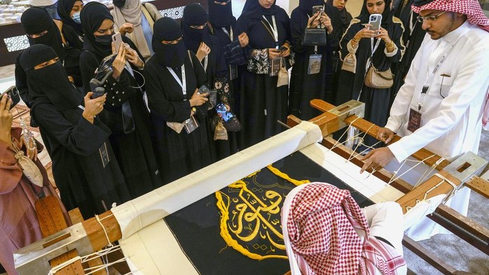 Intip Penyulaman Kiswah dengan Benang Emas Saudi Ahmed Al Humani embroiders Islamic calligraphy in the final stages of the preparation of a drape, or Kiswa, that covers the Kaaba, a cube-shaped structure at the heart the Grand Mosque, at the Media Oasis exhibition in Mecca, Saudi Arabia, Wednesday, June 21, 2023. Muslim pilgrims are converging on Saudi Arabia's holy city of Mecca for the largest hajj since the coronavirus pandemic severely curtailed access to one of Islam's five pillars. (AP Photo/Amr Nabil)