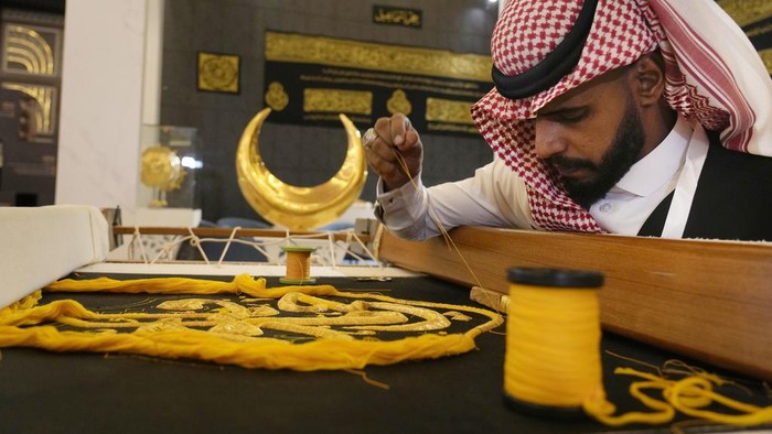 Intip Penyulaman Kiswah dengan Benang Emas Saudi Ahmed Al Humani embroiders Islamic calligraphy in the final stages of the preparation of a drape, or Kiswa, that covers the Kaaba, a cube-shaped structure at the heart the Grand Mosque, at the Media Oasis exhibition in Mecca, Saudi Arabia, Wednesday, June 21, 2023. Muslim pilgrims are converging on Saudi Arabia's holy city of Mecca for the largest hajj since the coronavirus pandemic severely curtailed access to one of Islam's five pillars. (AP Photo/Amr Nabil)