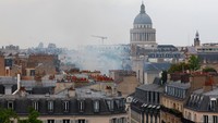 Foto menunjukkan kepulan asap besar membubung dari gedung-gedung di Paris setelah sebuah ledakan mengguncang jalan di Latin Quarter yang sibuk, Rabu (21/6/2023). Ledakan itu menyebabkan fasad sekolah desain yang populer di kalangan siswa asing runtuh, meledakkan jendela dan menyalakan api besar.