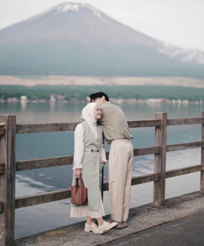 Baju couple tidak melulu harus sama. Lihat gaya Dinda Hauw dan Rey Mbayang yang tampak serasi hanya dengan nuansa hijau sage. Foto: Instagram @dindahw