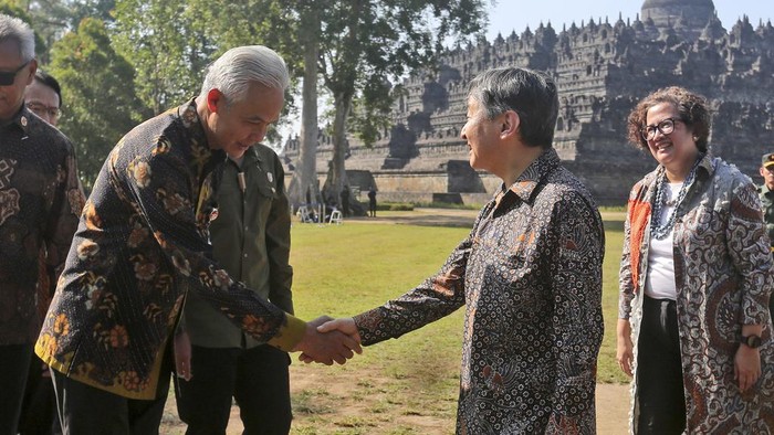Japan's Emperor Naruhito, center right, shakes hands with Central Java Governor Ganjar Pranowo as the Director of Borobudur Temple Tourism Park Febrina Intan, right, looks on during his visit at the 9th century Borobudur Temple in Magelang, Indonesia, Thursday, June 22, 2023. Naruhito is currently on a weeklong visit in the country in his first official foreign trip since ascending the Chrysanthemum Throne in 2019. (AP Photo/Slamet Riyadi)