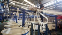 Pekerja melakukan proses penarikan benang filamen dari olahan limbah botol plastik bekas untuk pembuatan fiber dacron di Pabrik PT Inocycle Technology Group di Pasar Kemis, Kabupaten Tangerang, Banten, Rabu (21/6/2023).