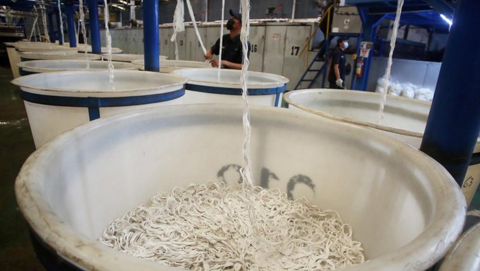 Pekerja melakukan proses penarikan benang filamen dari olahan limbah botol plastik bekas untuk pembuatan fiber dacron di Pabrik PT Inocycle Technology Group di Pasar Kemis, Kabupaten Tangerang, Banten, Rabu (21/6/2023). PT Inocycle Technology Group setiap tahunnya mampu memproses tiga miliar sampah botol plastik bekas menjadi dacron, sebagai bahan baku pembuatan bantal, peralatan rumah tangga serta bahan baku otomotif untuk memenuhi kebutuhan pasar lokal serta diekspor ke Asia dan Eropa. ANTARA FOTO/Muhammad Iqbal/YU