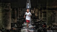 Seorang anak bermain di kawasan Kolong Tol Papanggo, Jakarta Utara, Kamis (22/6/2023).  