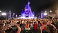 Pada pagi titik balik matahari musim panas, para pemeran Walt Disney World melakukan peregangan di Cinderella Castle di Magic Kingdom, di Lake Buena Vista, Florida, dalam pertemuan menjelang fajar sebelum taman dibuka. Sesi yoga tim untuk memperingati Hari Yoga Internasional. Diperkirakan 2.000 karyawan berpartisipasi dalam acara. AP/Joe Burbank 