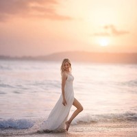 Wanita berambut pirang ini pose bak model dengan latar belakang desiran ombak dan cahaya jingga matahari. Foto: Instagram/@varshaadhikumoro