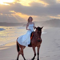 Varsha menunjukkan kemampuannya menunggang kuda dengan gestur anggun. Foto: Instagram/@varshaadhikumoro