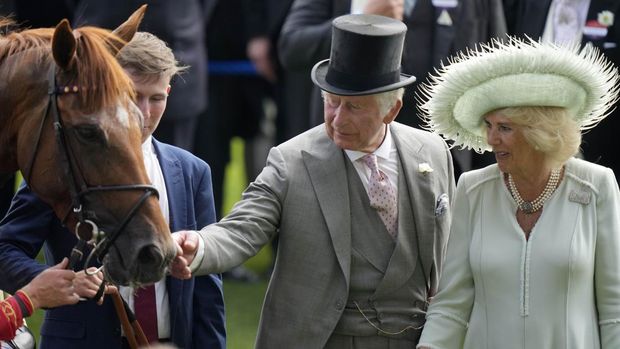 Britain's King Charles III touches a racing horse as Camilla, the Queen Consort looks on during Ladies Day of the Royal Ascot horse racing meeting, at Ascot Racecourse in Ascot, England, Thursday, June 22, 2023.(AP Photo/Alastair Grant)