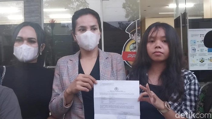 Deca (tengah) saat membuat laporan ke Polda Sumut.
