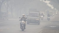 Pengendara kendaraan bermotor melintas di tengah kabut asap akibat kebakaran lahan di Kecamatan Liang Anggang, Banjarbaru, Kalimantan Selatan, Jumat (23/6/2023).   