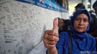 Seorang warga menunjukan jempol yang berdarah sebelum membunuhkannya di kain putih.  