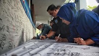 Para relawan membubuhkan cap jempol darah itu di kain putih yang telah disediakan, mereka juga membubuhkan tanda tangannya.  