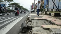 Warga melintas di trotoar Jalan Margonda, Depok, Jumat (23/6/2023).  