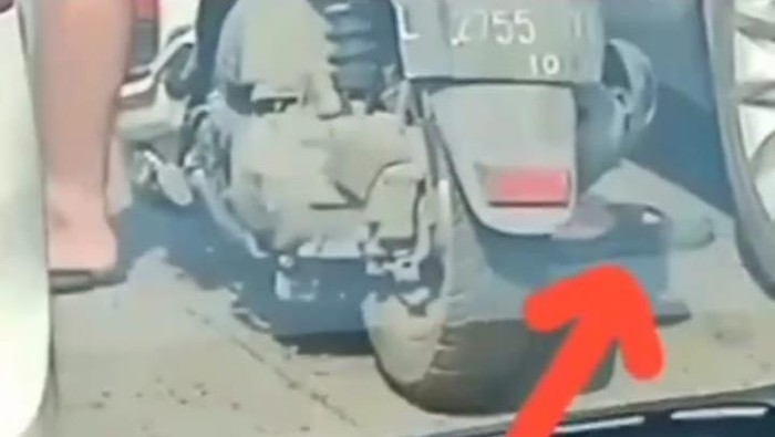 Pemotor yang ganjal ban mobil dengan paku di sandalnya.