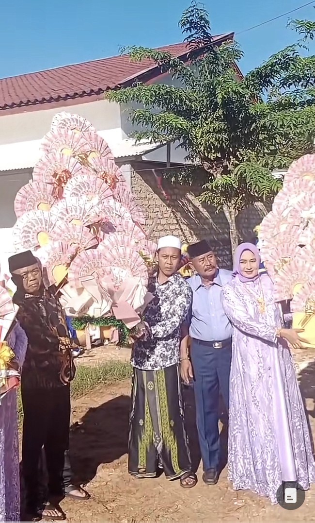 Buket uang itu berukuran jumbo hingga menutupi tubuh orang dewasa. Ada dua buket uang yang berukuran jumbo dan satu lagi berukuran sedang. Selain itu ada logo kunci mobil. “Penyerahan dr besan Lamaran #lamaranmadura #lamaran #sepudi #sumenepmadura #lamaranviral2023 #lamaranviral, tulis akun TikTok @riyanputramadura. Foto: Dok. TikTok @riyanputramadura.