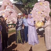 Momen penyerahan seserahan dari pengantin pria untuk pengantin wanita ini viral di media sosial. Pasalnya rombongan pengantin pria membawa buket uang bentuk kipas berukuran jumbo dan memberikan mobil baru lengkap dengan BPKB. Foto: Dok. TikTok @riyanputramadura.