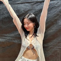 Kwon Eunbi memakai cardigan dan rok pendek berwarna putih. Namun hanya mengancingkan bagian atas cardigannya, sehingga mengekspos bagian payudaranya. Foto: dok. Instagram @silver_rain.__