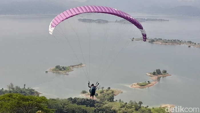 Kawasan Waduk Jatigede, Kabupaten Sumedang, menarik minat para atlet paralayang dari berbagai daerah untuk unjuk kebolehan. Aksi mereka pun menjadi hiburan tersendiri bagi para wisatawan, Minggu (25/6/2023).