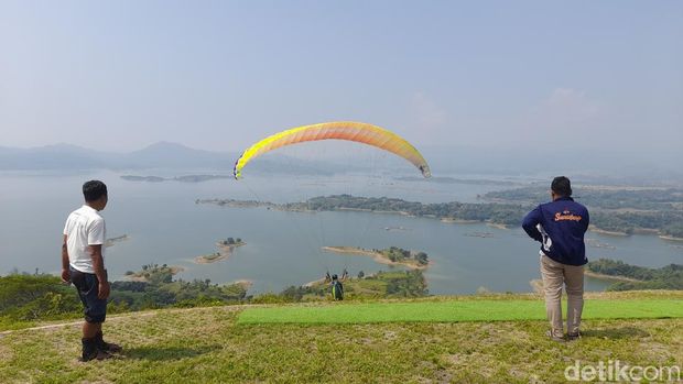 Kawasan Waduk Jatigede, Kabupaten Sumedang, menarik minat para atlet paralayang dari berbagai daerah untuk unjuk kebolehan. Aksi mereka pun menjadi hiburan tersendiri bagi para wisatawan, Minggu (25/6/2023).