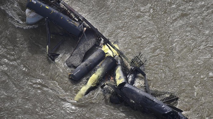 Portions of a freight train are seen in the Yellowstone River after an overnight railroad bridge collapse, near Columbus, Mont., Saturday, June 24, 2023. (Larry Mayer/The Billings Gazette via AP)