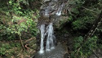 Foto udara memperlihatkan pengunjung menikmati wisata air terjun Wonua Momahe, di Desa Waworaha, Kecamatan Soropia, Konawe, Sulawesi Tenggara, Minggu (25/6/2023).